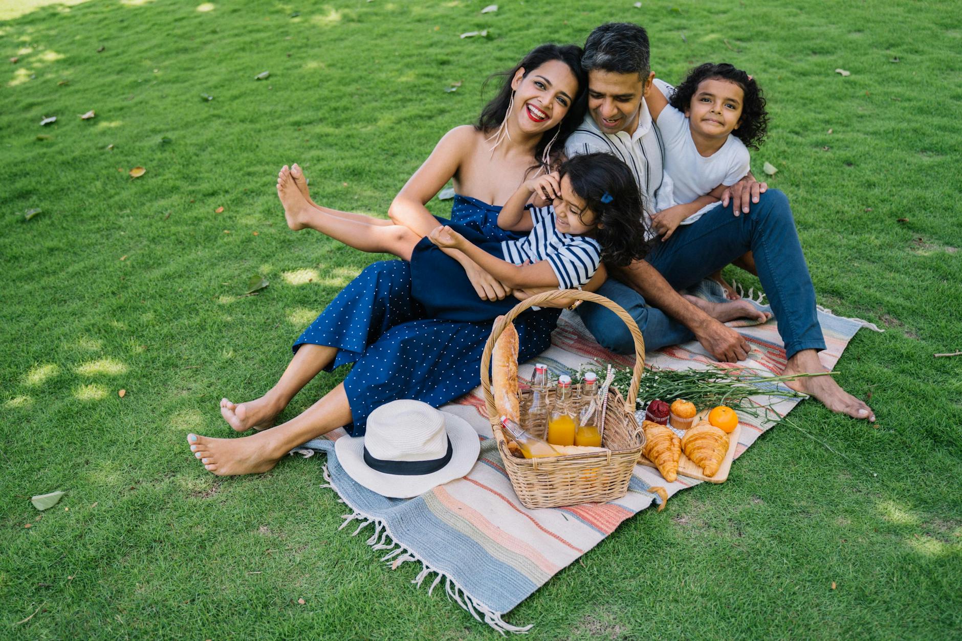 a family sitting on a picnic blanket