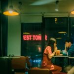 asian couple drinking cocktails in cafe at night