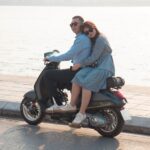 young couple riding a motorcycle along the sea coast