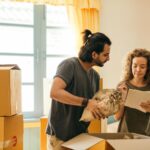 happy couple unpacking boxes in new home